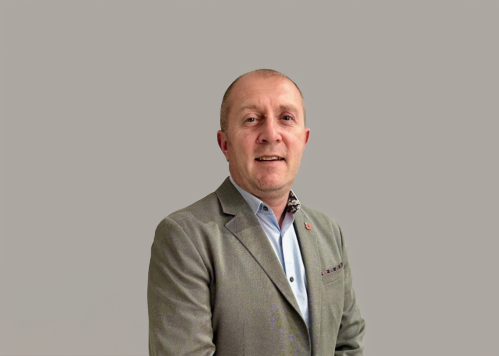 Kelvin drinkwater managing director of top uk electrical manufacturer and distributor of low-voltage and ev equipment CHINT SHIELD, standing behind a beige background